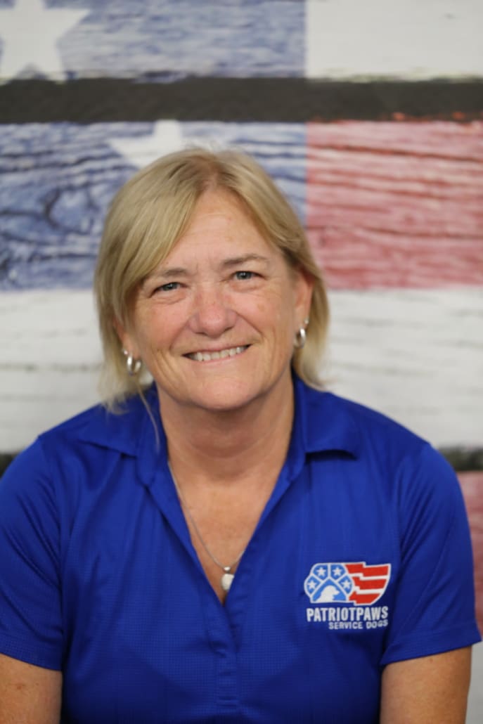 A woman in blue shirt smiling for the camera.