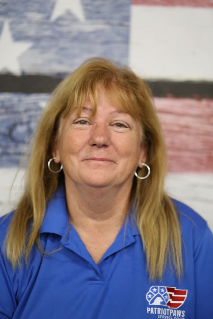 A woman with long blonde hair wearing blue shirt.