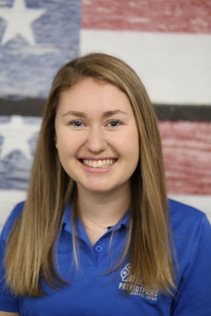 A woman in blue shirt smiling for the camera.