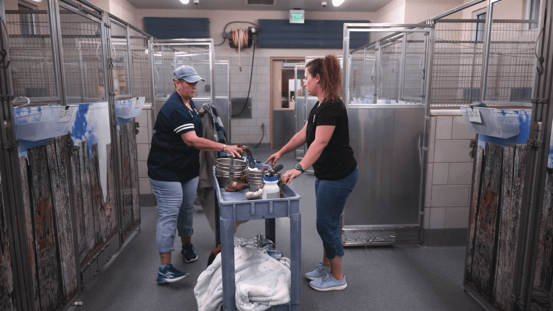 Two people standing in a room with food.