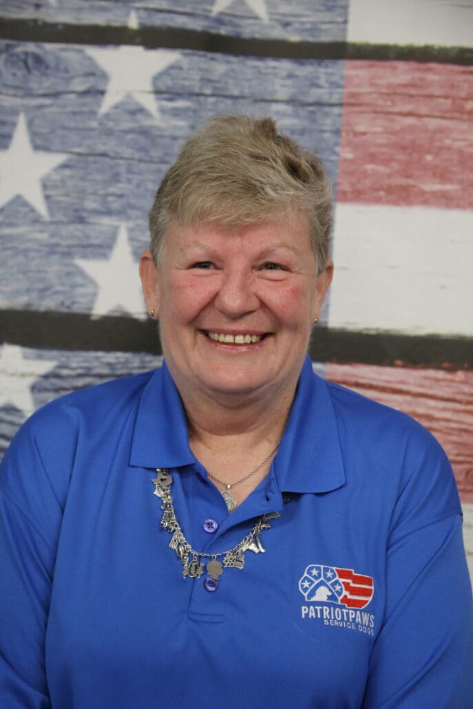 A woman with blonde hair and blue shirt smiling.