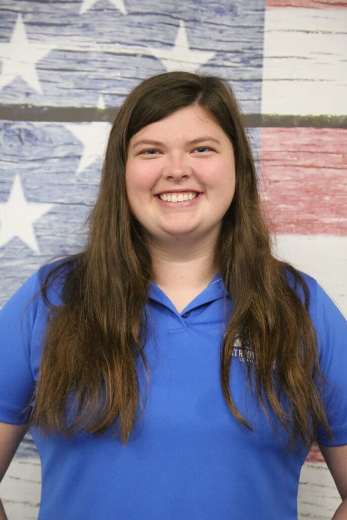 A woman in blue shirt smiling for the camera.